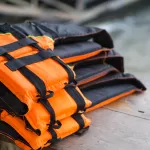 Closeup life jacket on wood table with river background, safety concept, selective focus